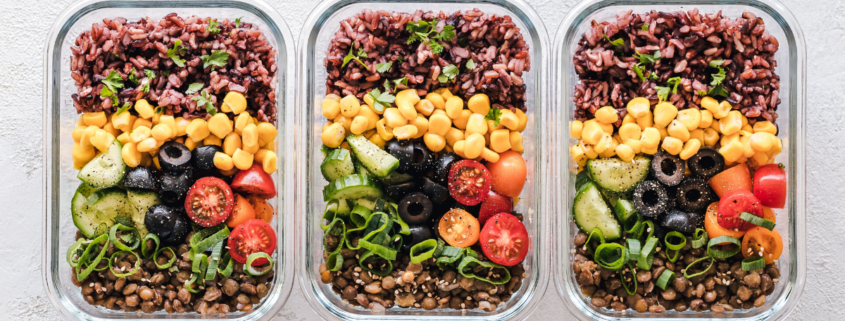 3 tupperwares filled with rice corn olives cucumbers tomatoes green onions and lentils