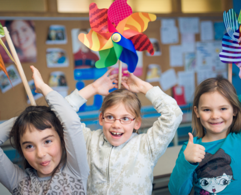 children with pinwheels on their heads