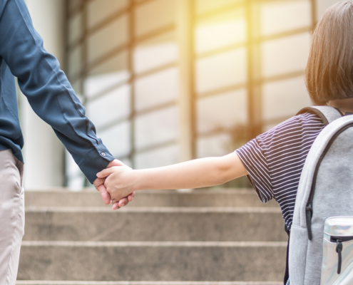 Adult and child holding hands