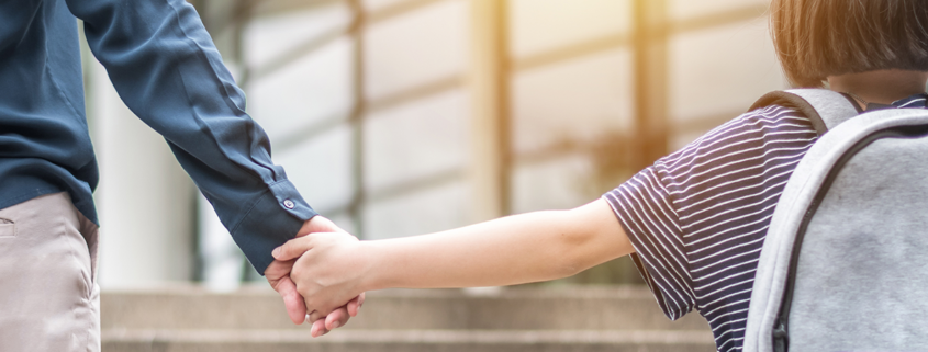 Adult and child holding hands