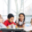 Children sitting around a cafeteria table talking