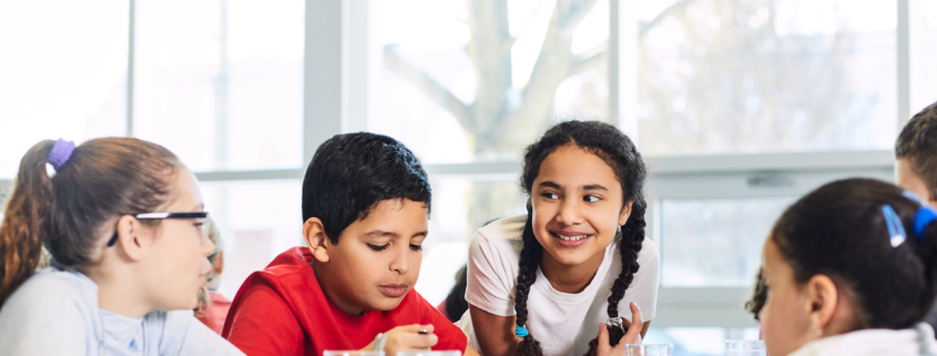 Children sitting around a cafeteria table talking