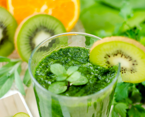 Green smoothy in a glass with kiwi garnish o