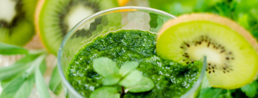 Green smoothy in a glass with kiwi garnish o