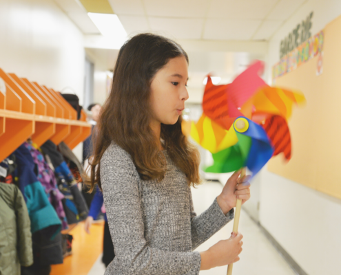 Little girl blowing on a pinwheel