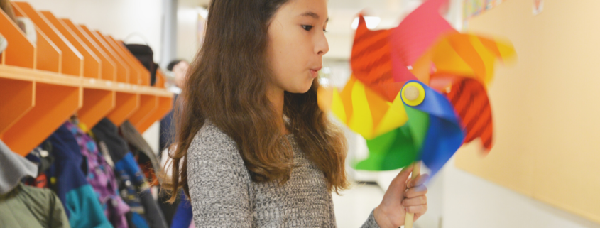 Little girl blowing on a pinwheel