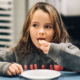 Child with long hair eating a piece of bread