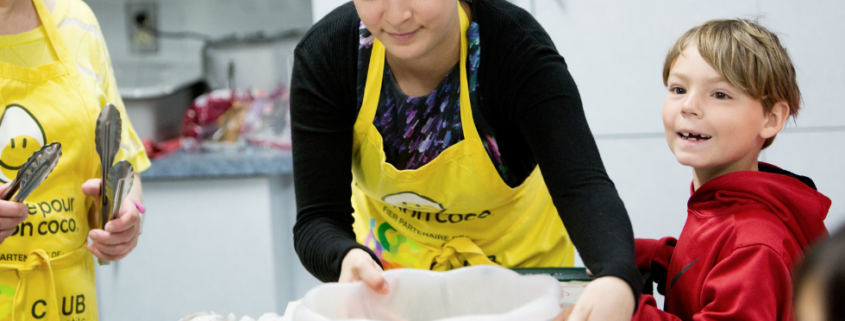 Volunteers with child making breakfast