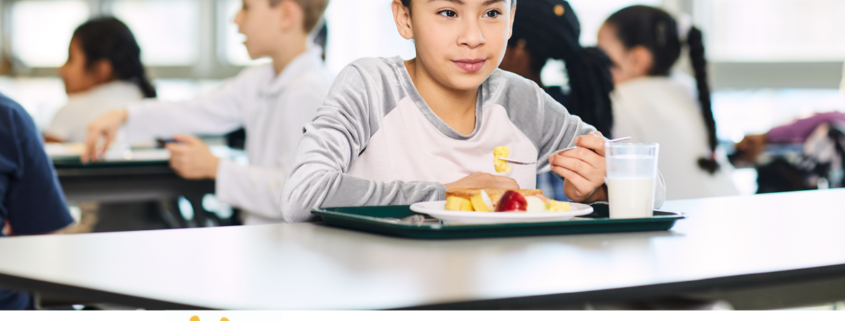 Child eating breakfast in cafeteria