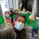 Man and children wearing masks while holding green compost buckets