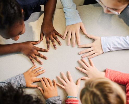 Kids putting hands together on the table