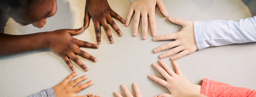 Kids putting hands together on the table