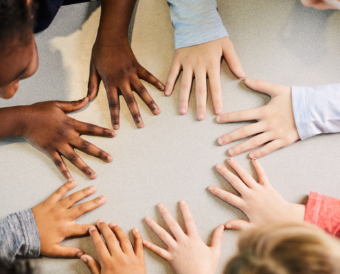 Kids putting hands together on the table