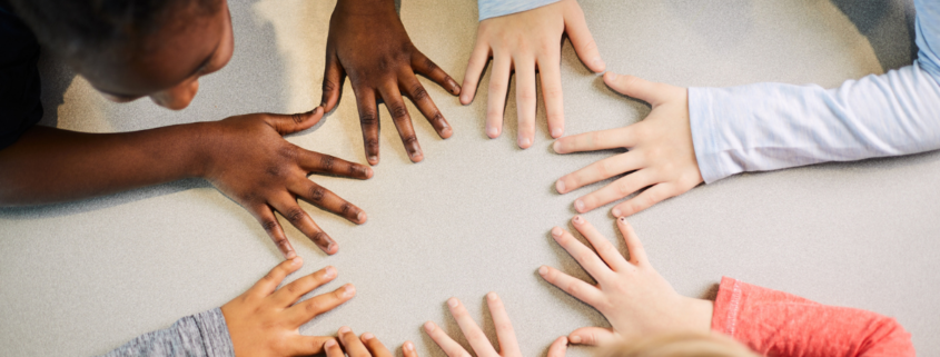 Kids putting hands together on the table