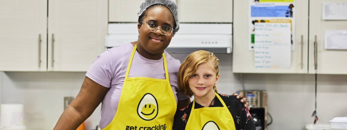 Volunteer and young volunteer in kitchen